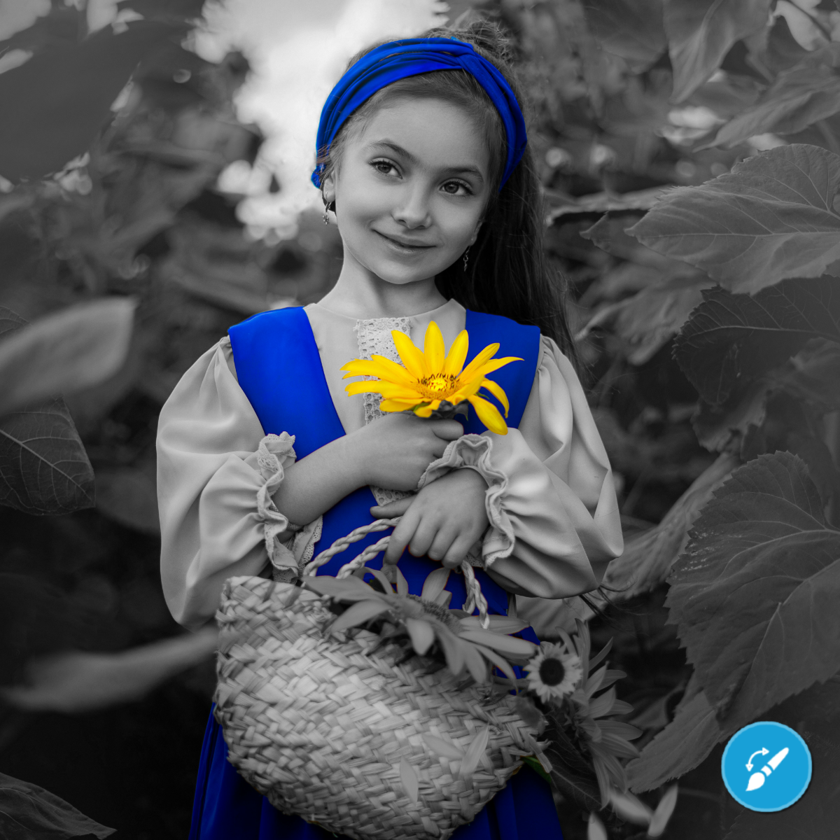 Child in traditional dress holding a sunflower, with a black and white background.